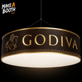 Circle hanging banner with gold GODIVA lettering and horse emblem